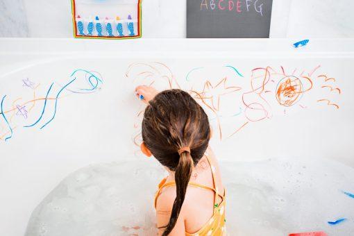 badkrijtjes kind speelt in bad met badkrijt