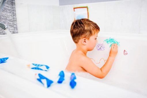 Badkrijtjes kind speelt in bad met badkrijt