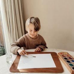 kind schilderen op houten tekenplank