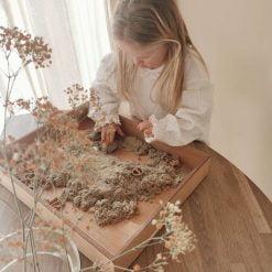 spelend kind met houten speelbak